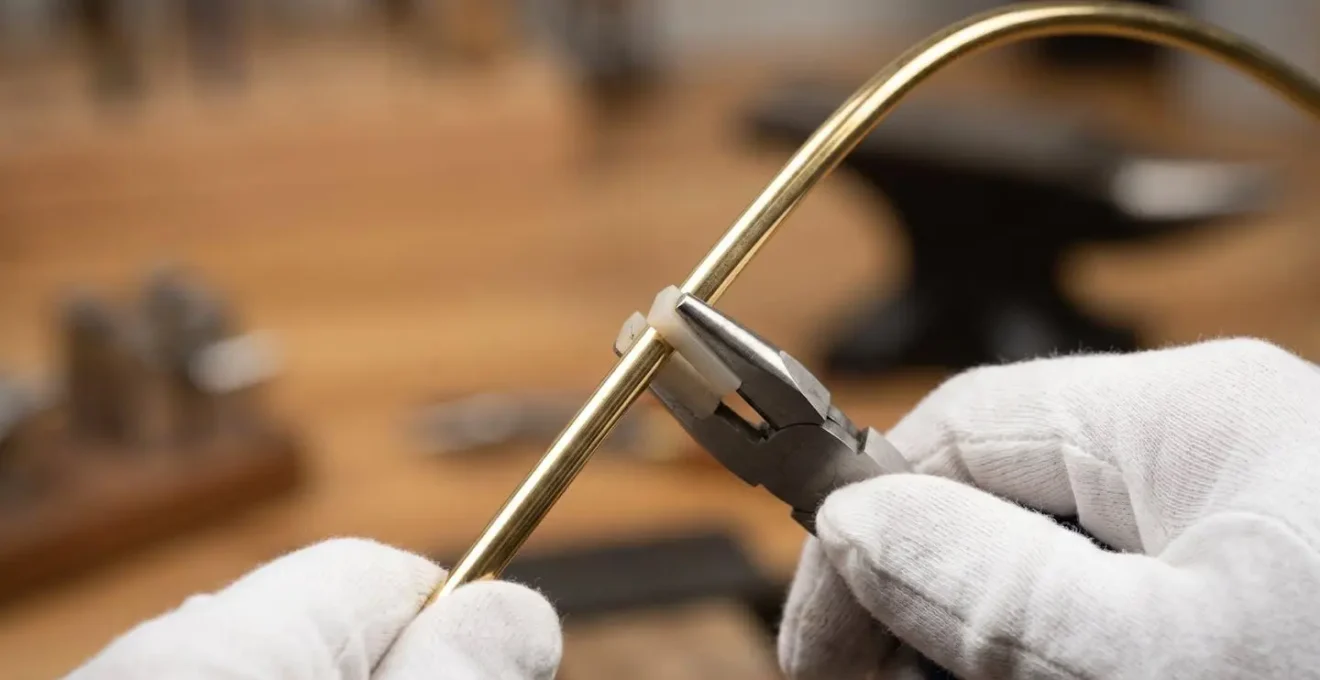 Macro close-up of brass rod being shaped with precision tools for artifact mounting