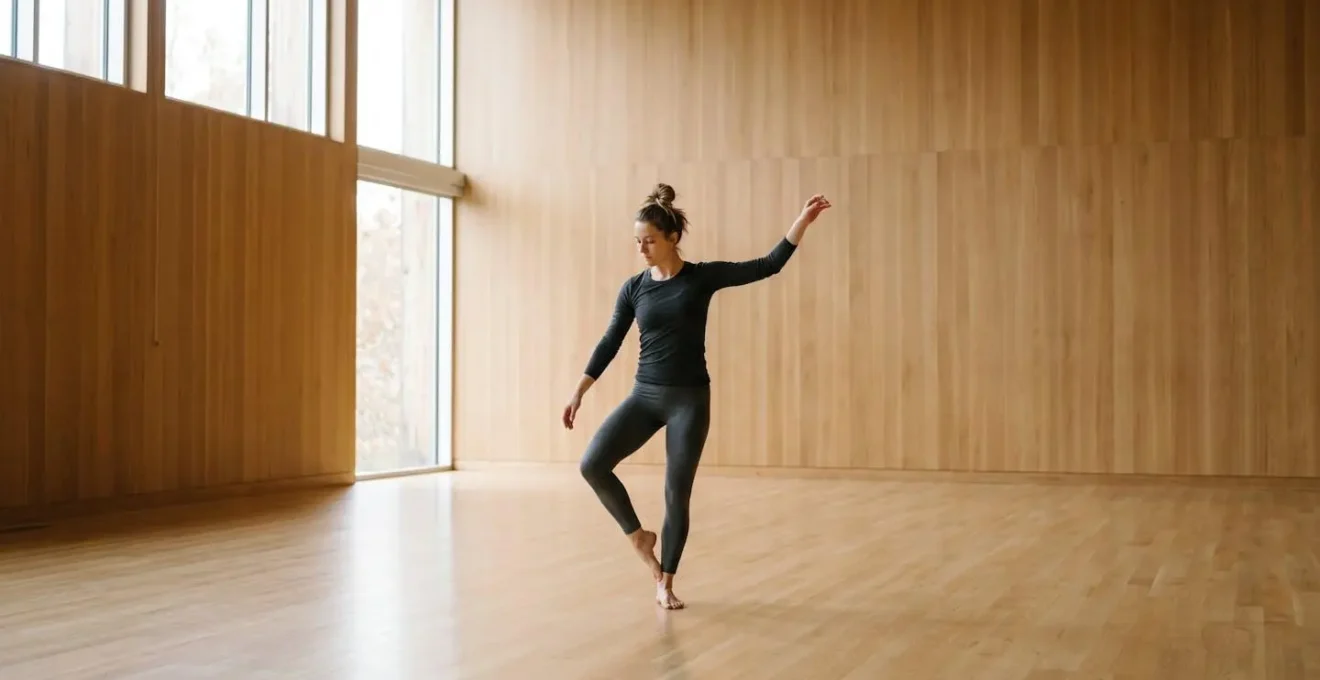 Wide environmental shot of performer executing ground-up mobilization sequence in spacious studio