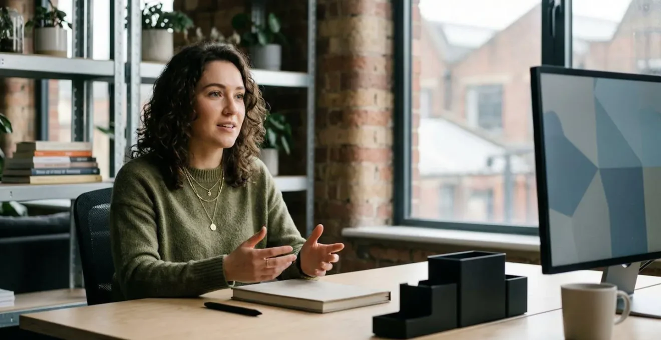 Freelance graphic designer in modern London workspace discussing project pricing